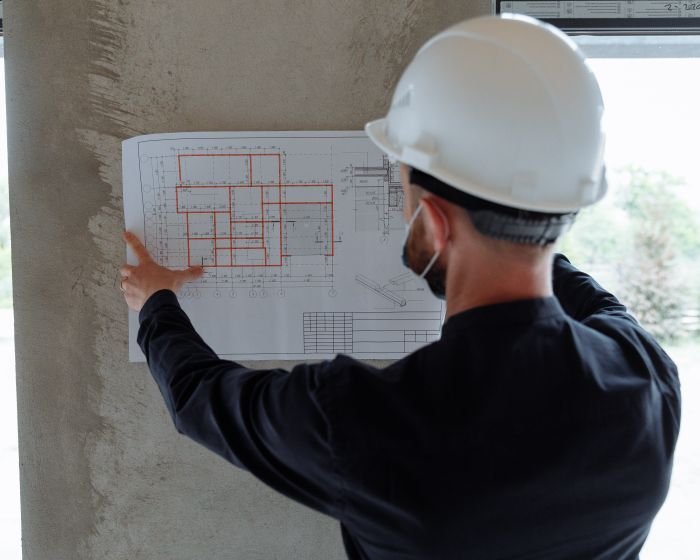 A contractor reviewing building plans on site
